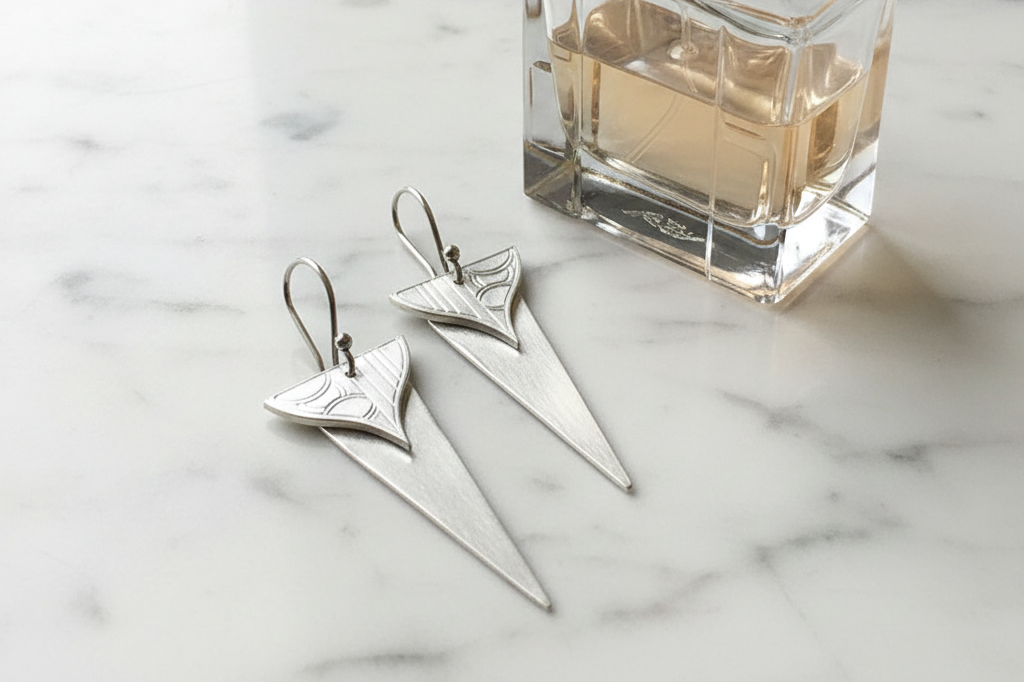Broadway Earrings next to art deco perfume bottle - clean composition