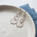 Curved Link earrings on a ceramic tray
