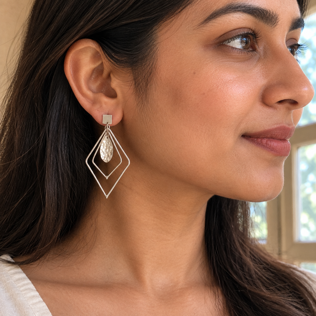 Prism sterling silver drop earrings on a pebble outdoors