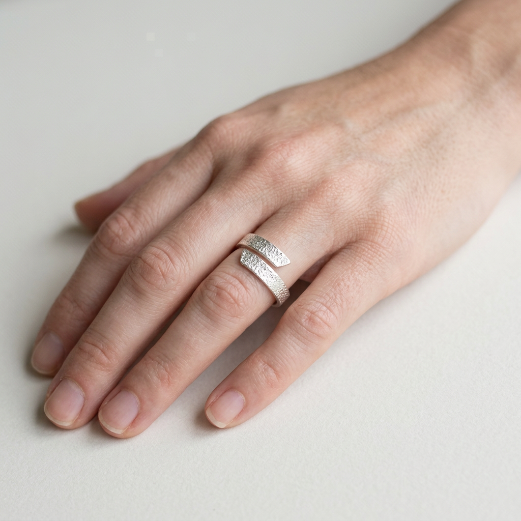 Frosted-textured adjustable silver ring on a slender finger