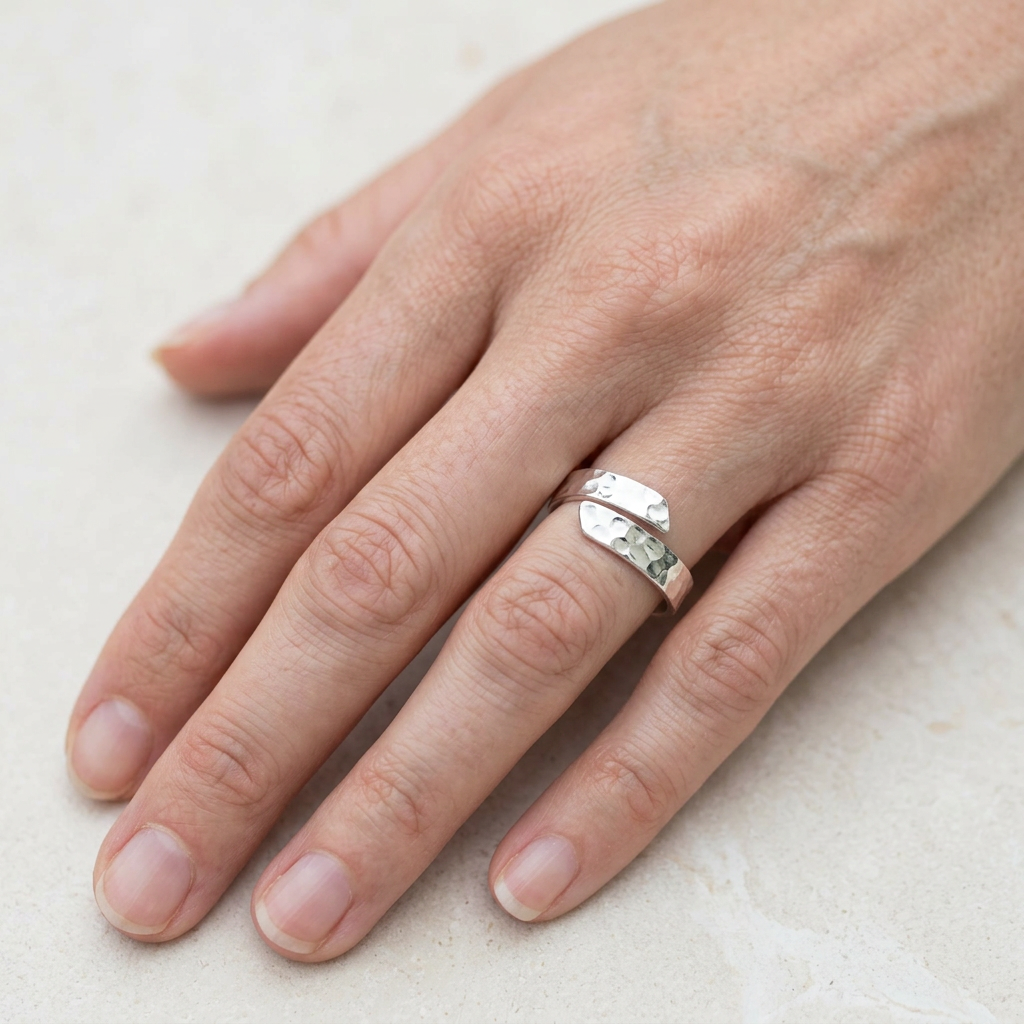 Hammered adjustable silver ring on a slender hand