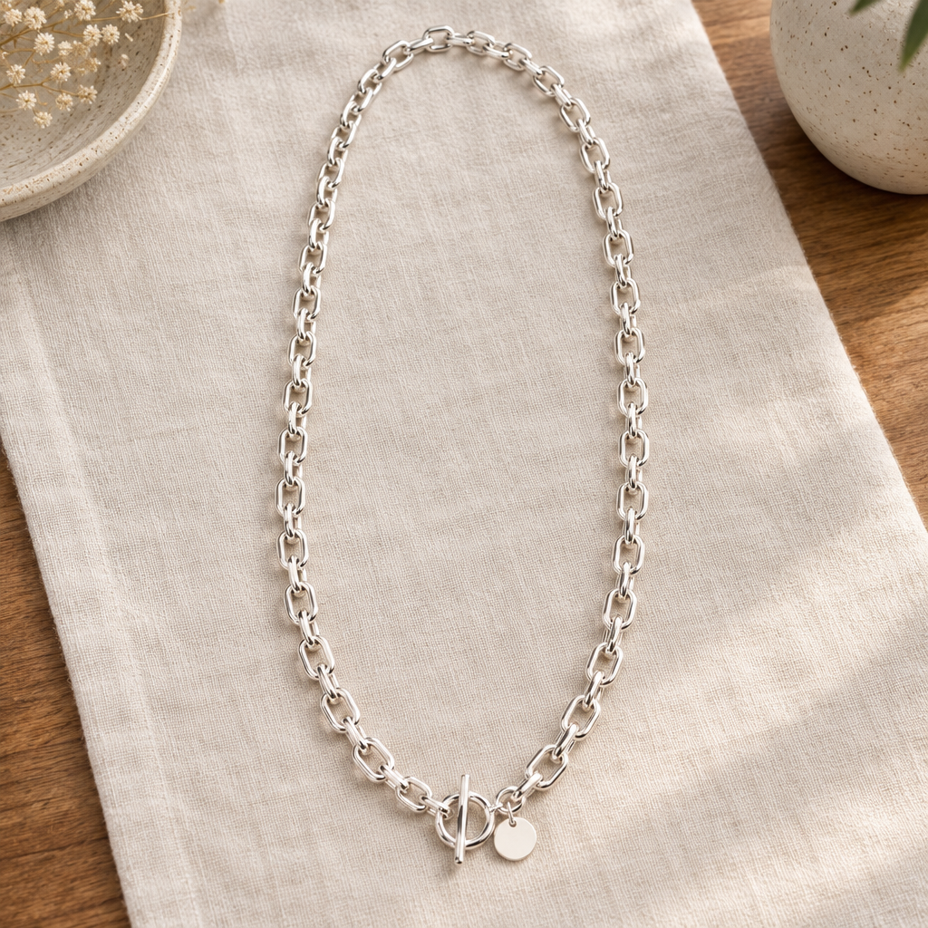Long anchor chain necklace arranged on indoor linen