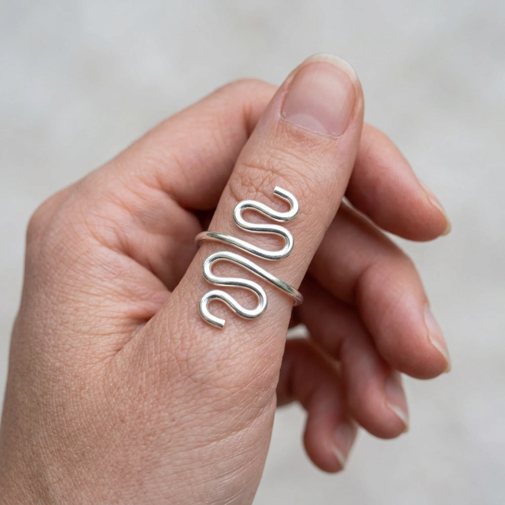 Longer silver snake ring on a young adult’s slender thumb