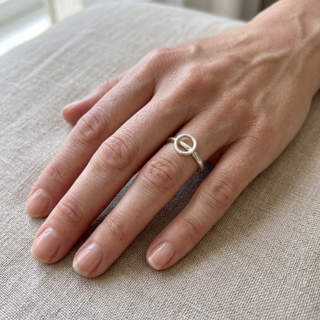 Open circle silver ring on a slender finger