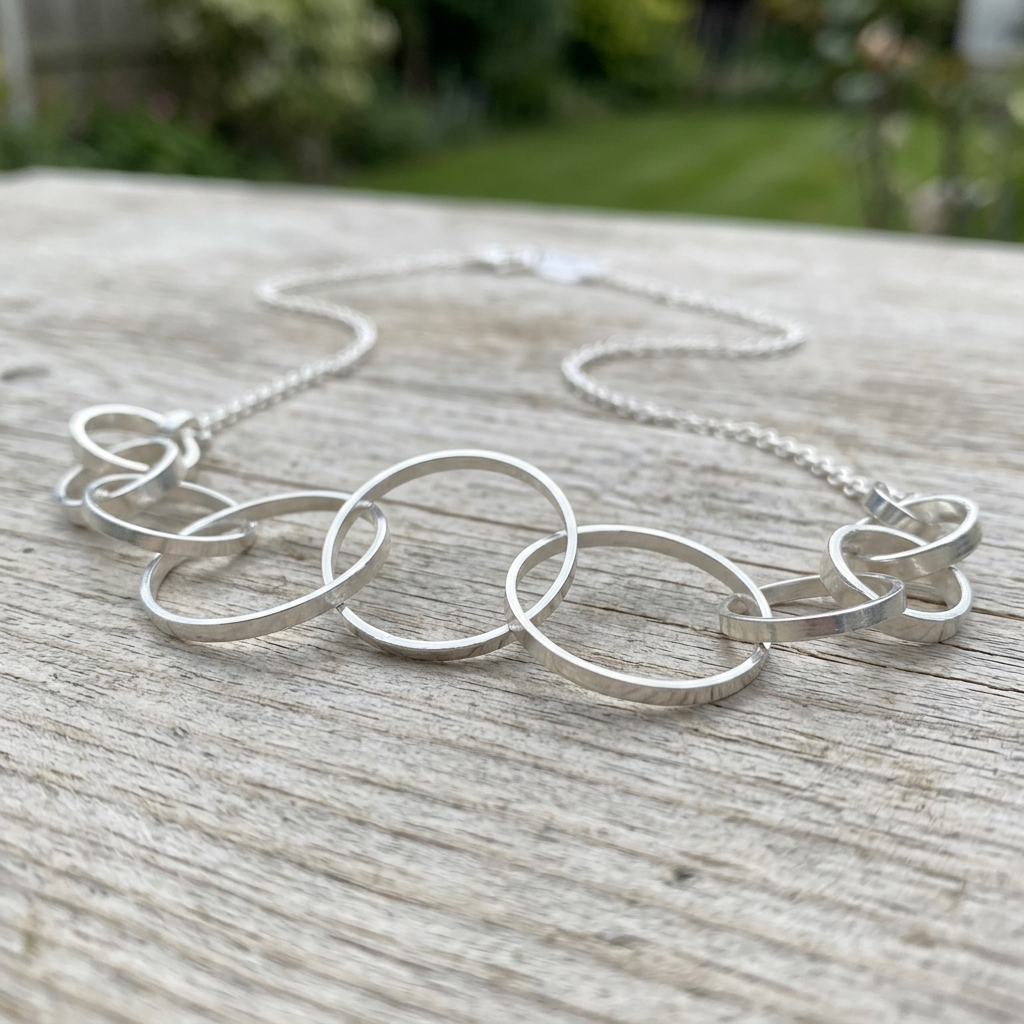 Orbit necklace on weathered wood outdoors
