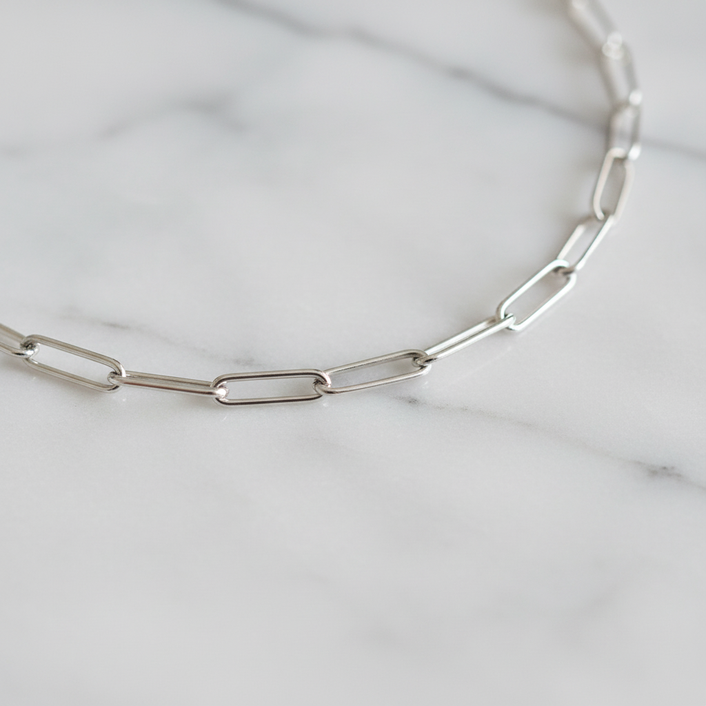 Section of paperclip chain necklace on indoor surface