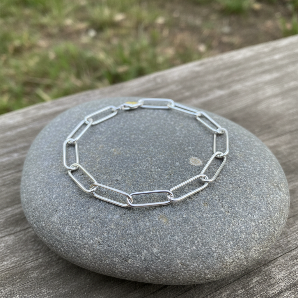 Silver paperclip chain bracelet on natural outdoor surface