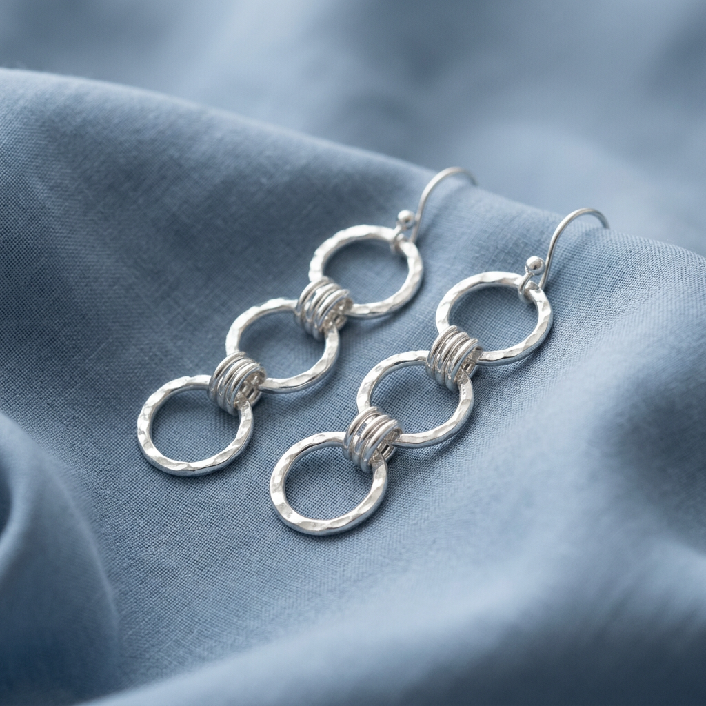 Triple Link earrings on softly folded dusty-blue fabric