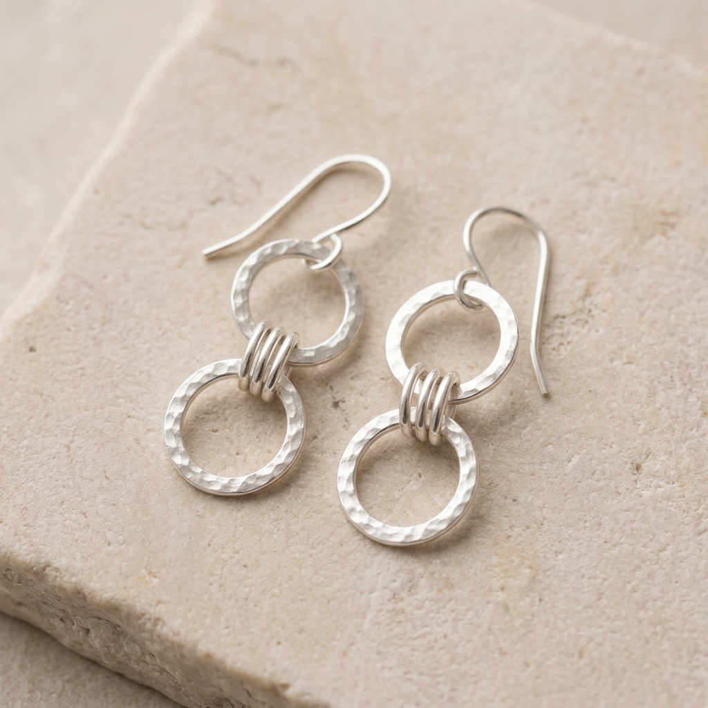 Two-drop Triple Link earrings on pale limestone