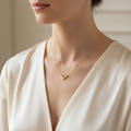 Woman wearing small gold chevron pendant