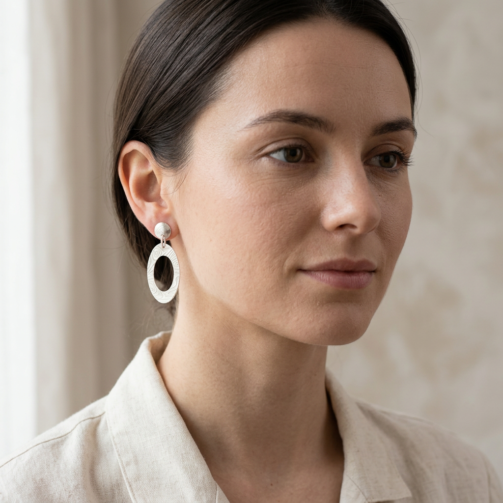Younger dark-haired woman wearing Engraved Oval earrings